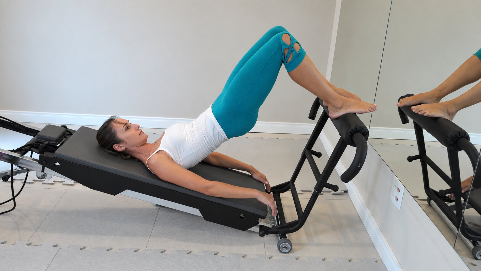 Aluna praticando Gravital Pilates no aparelho inclinado